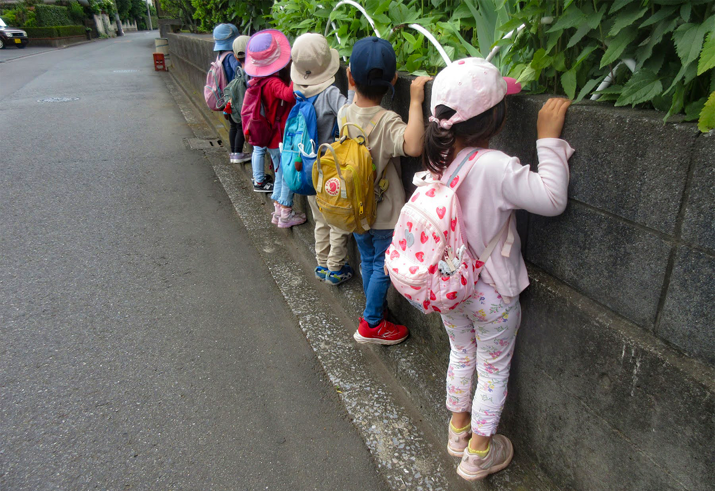 子どもたちの日常壁沿いを歩く子供たち