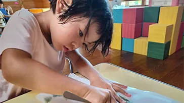藍染めの生場染めを一生懸命こする子ども