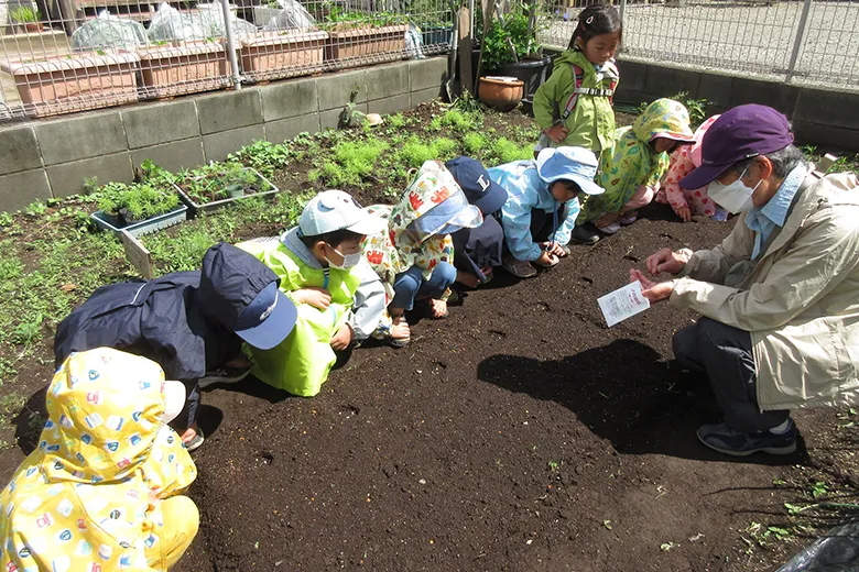 大切にしていること畑で種を植える子供たち